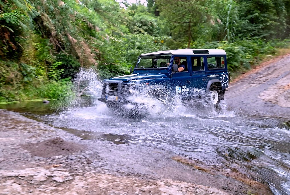 Jeep splashing through a river crossing on an off-road track, São Miguel